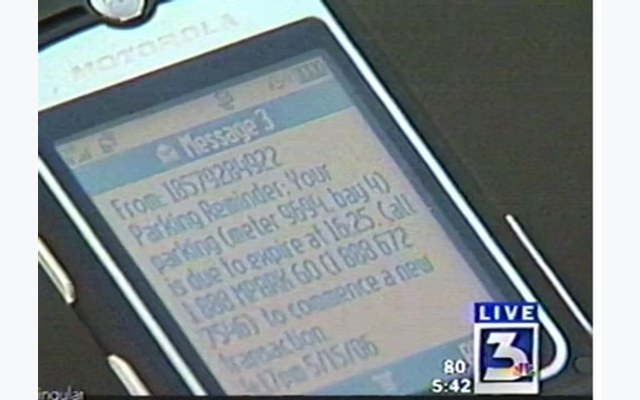 Motorola flip phone displaying mPark parking SMS confirmation, 2006