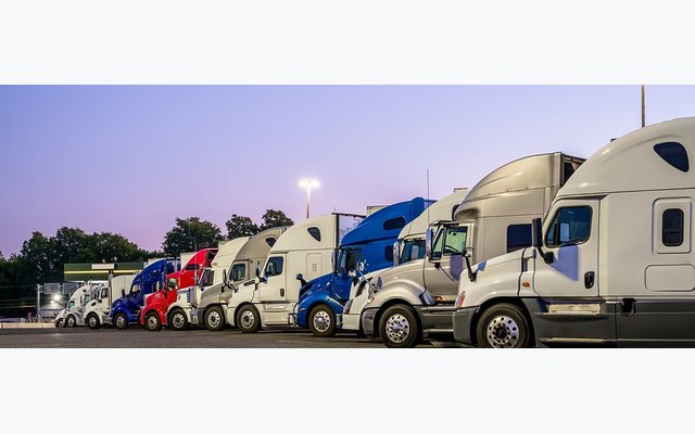 Row of semi-trucks parked at a commercial truck stop